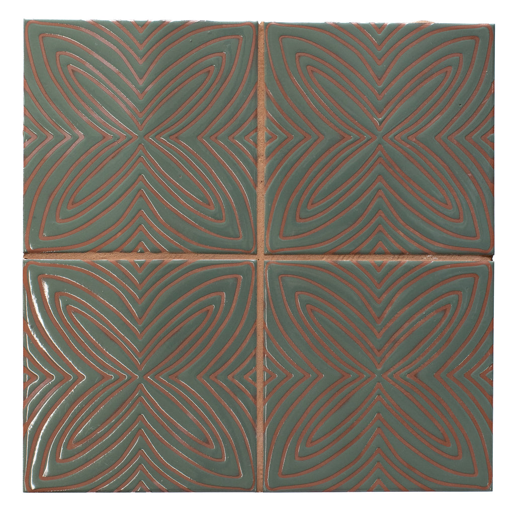 Four green tiles with red geometric patterns arranged in a grid.